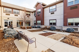 The courtyard with park benches and sidewalks at Coal Creek Post Acute